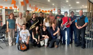 Foto: Musikdozent Ralph Himmler (kniend vorne rechts) probte einen Tag lang mit der Schüler-Lehrer-Band der HOLA. Schulleiter Martin Göbler und Werner Bayer von der IGHA (hintere Reihe von r. n. l.) freuen sich jedes Jahr über das musikalische Event.