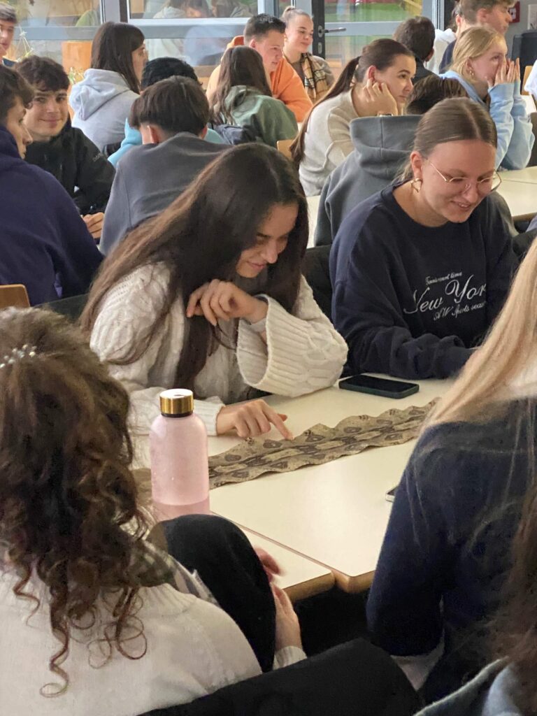 Die Schülerinnen und Schüler schauen sich die Schlangenhaut näher an