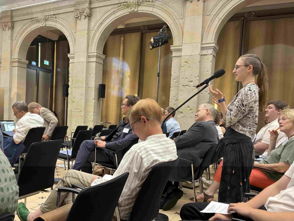 Teilnehmer der Exkursion stellen während der Diskussion zum Thema „Gelingende Solidarität“ Fragen an die Experten des Podiums.