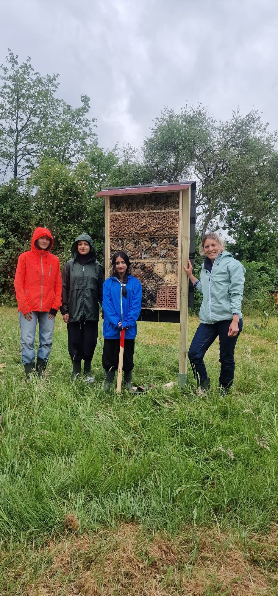 Foto: Schakila Bakhschi (10E), Adelh Al Ammari (10E), Meha Mehar (10E) und Swantje Stein-Hellmann sind stolz auf ihr selbst gebautes Insektenhotel.