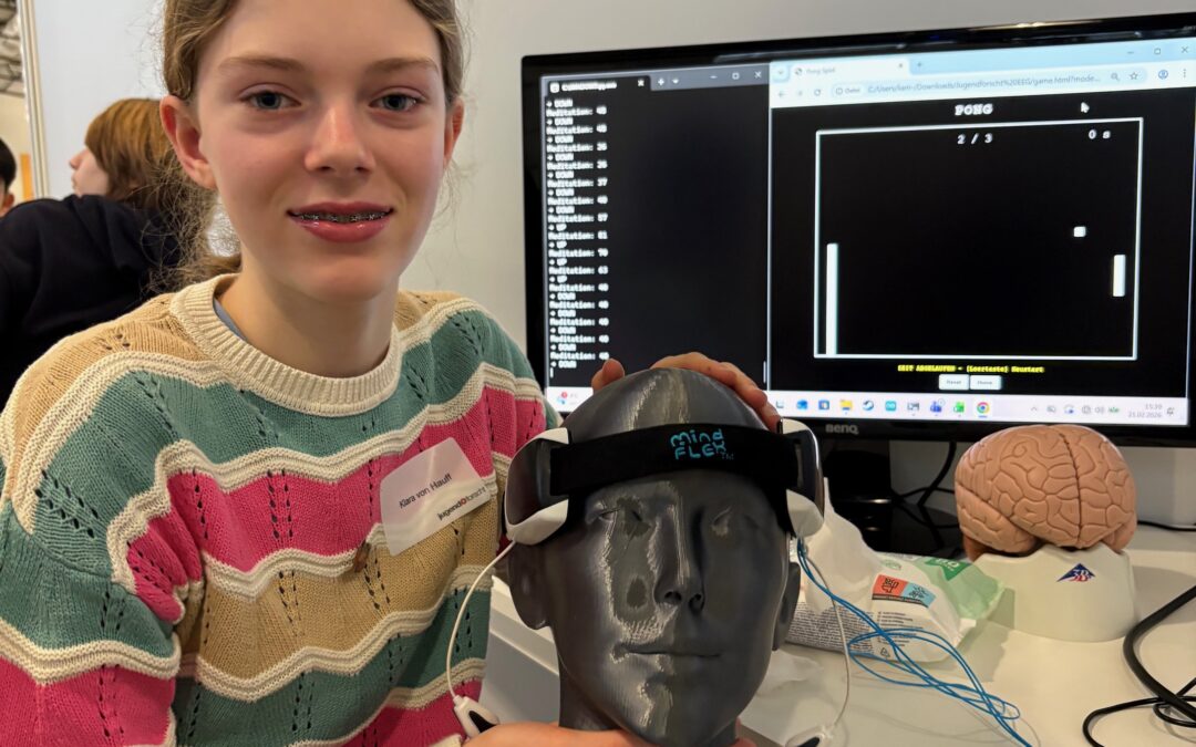 Foto: So hat man sich das Projekt vorzustellen. Das Bild zeigt Klara mit dem Headset, im Hintergrund sieht man auf dem Monitor das Pong-Spiel.