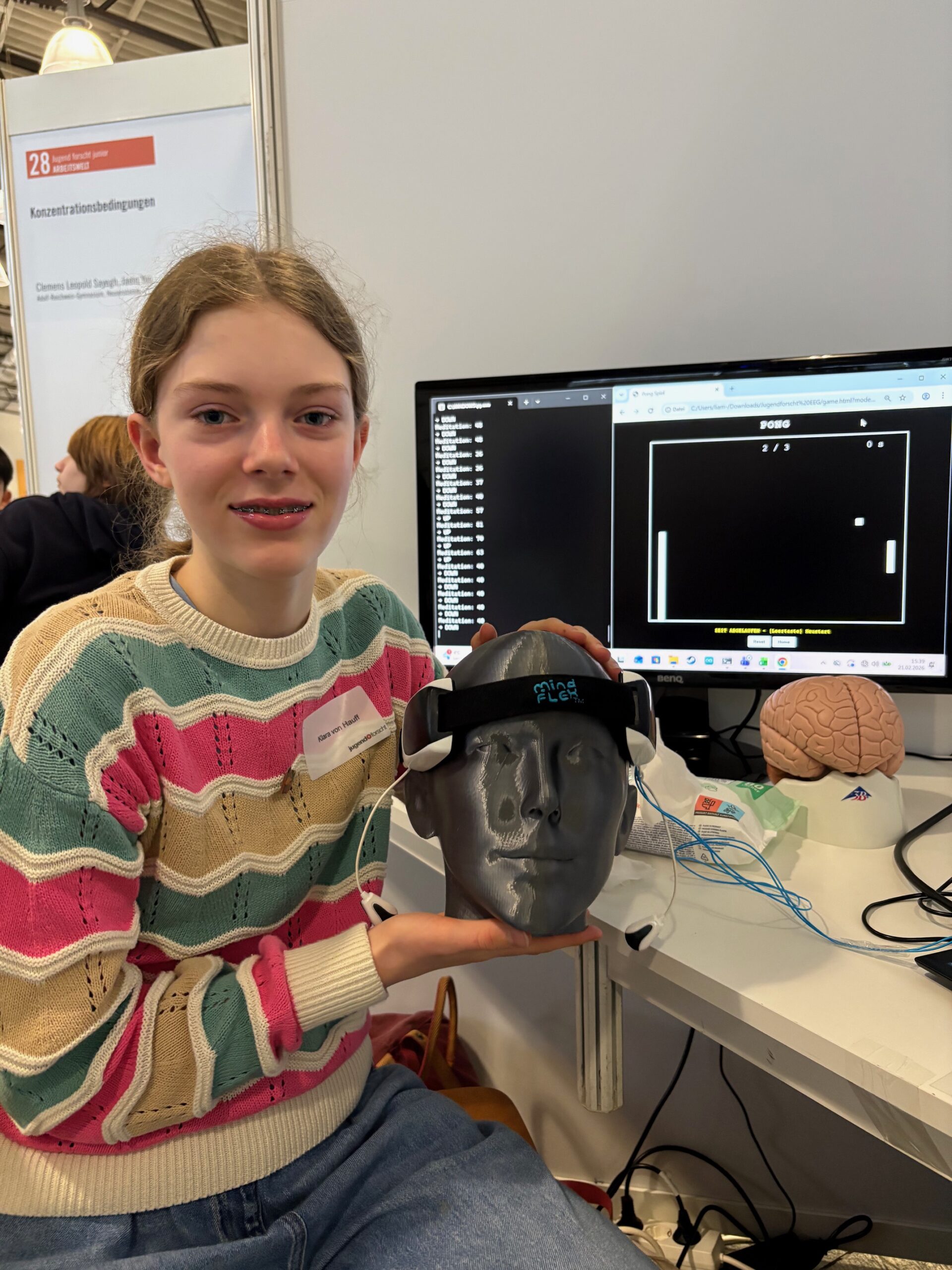 Foto: So hat man sich das Projekt vorzustellen. Das Bild zeigt Klara mit dem Headset, im Hintergrund sieht man auf dem Monitor das Pong-Spiel.