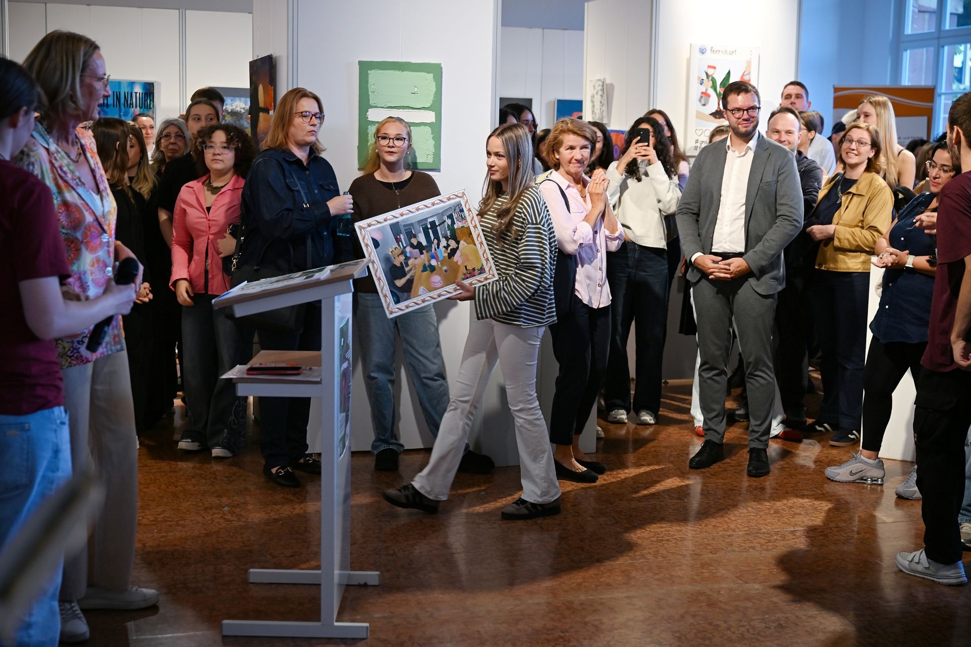 Auf beiden Bildern ist die Preisträgerin der HOLA Anastasia Dombrowski (aktuell E1) zu sehen. Auf einem Foto ist auch Milena Kuziola (Q3) zu sehen, die als Preisträgerin des letzten Jahres Mitglied der diesjährigen Jury war und die Urkunde überreichte.